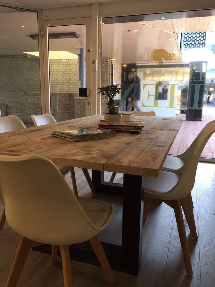 De lange houten tafel bij het raam van de salon